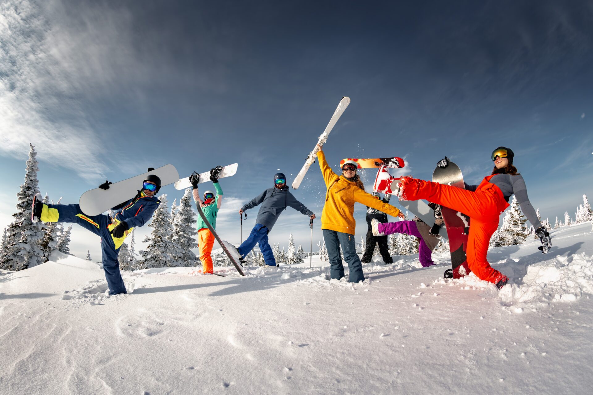 A group of skiiers in multi-coloured clothing, posing for the camera.