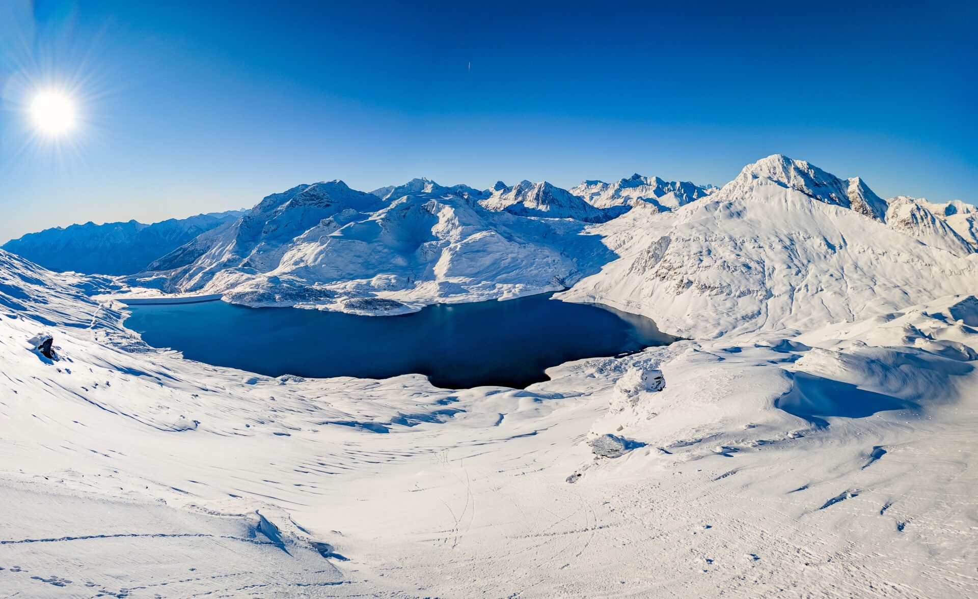 A dronal view of the Val Cenis mountains on a blue sky day.