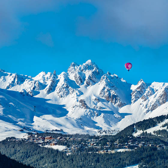Pink hot air balloon over Courchevel valley in the French Alps