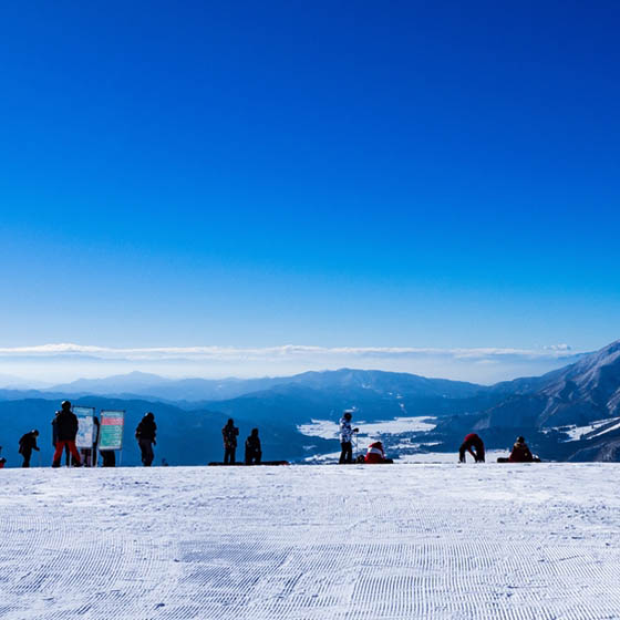 Skiers in Hakuba Valley with bright blue sky