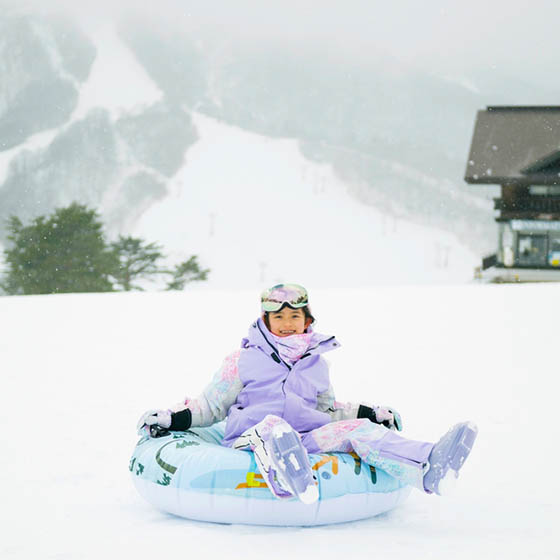 School girl sledging on a snowy mountain in Japan
