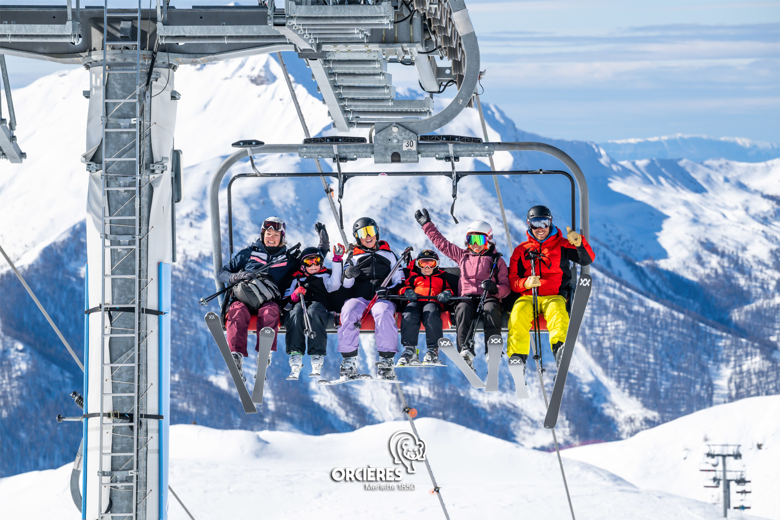 Group sitting on a chairlift in Orcieres Merlette, France
