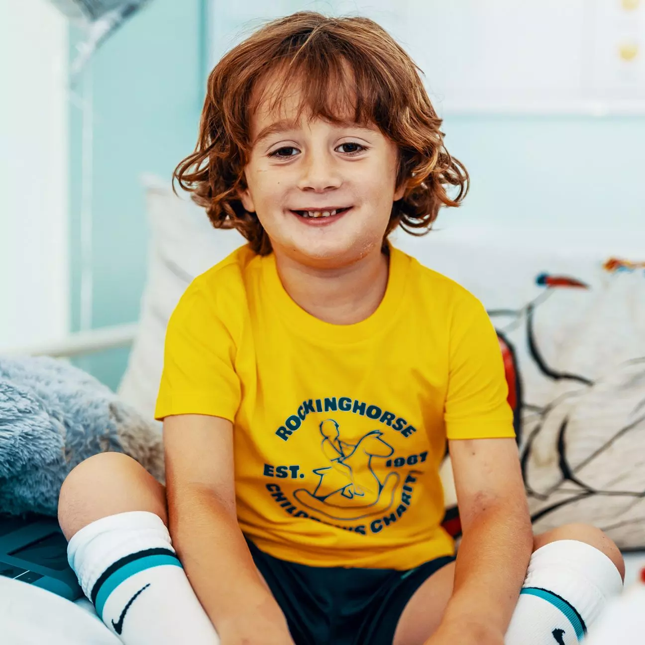 Child wearing a Rockinghorse Children's Charity yellow t-shirt